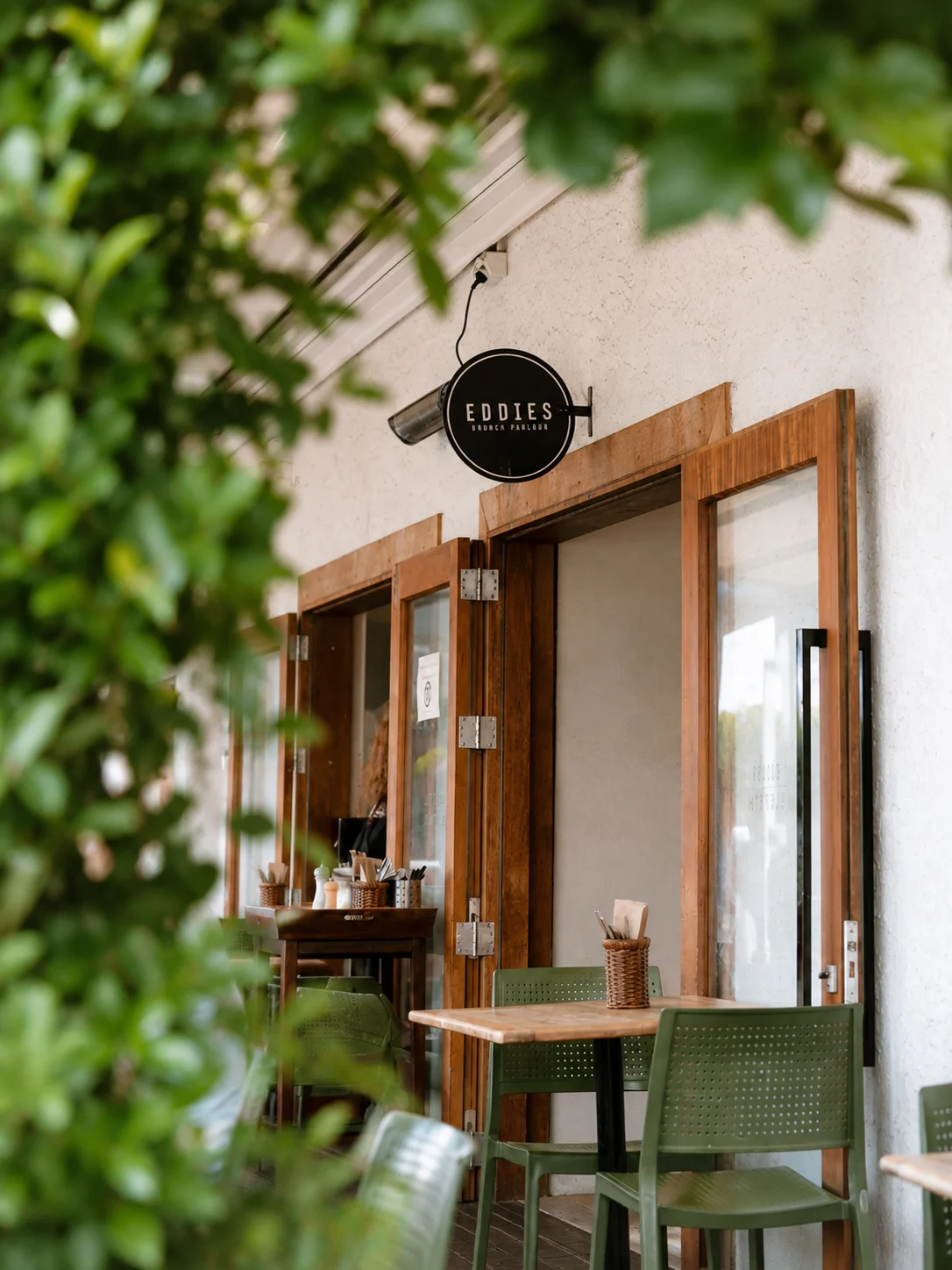 Leafy entrance and outdoor tables at Eddie's Brunch Parlour